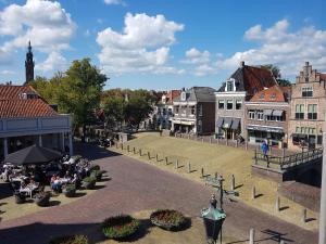 a group of people sitting at tables in a town square at De Krasse Man in Edam