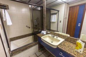 a bathroom with a sink and a mirror at Fiesta Bahia Hotel in Salvador