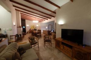 a living room with a couch and a flat screen tv at Thatch by the Sea in Blythedale