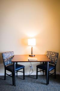 una mesa con dos sillas y una lámpara. en The Inn at Harbor Shores, en Saint Joseph