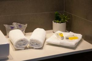 a bathroom counter with towels and cleaning products on it at Hostal Goya in Barcelona +102 photos