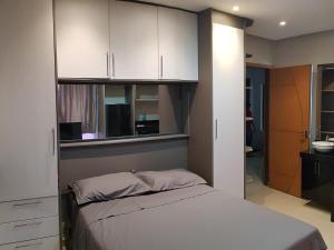 a bedroom with a bed and white cabinets at Loft Lindo no Centro in Marabá