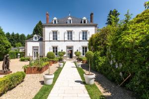 an exterior view of a house with potted plants at La Chapelle Saint Martin in Nieul