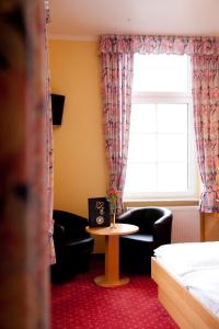 Zimmer mit einem Bett, einem Tisch und einem Fenster in der Unterkunft Hotel Zwei Mohren in Rüdesheim am Rhein