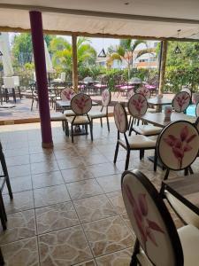 um grupo de mesas e cadeiras num restaurante em Orquidea GuestHouse Spa & Restaurant em Maputo