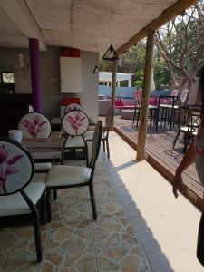 - un groupe de chaises et de tables dans un restaurant dans l'établissement Orquidea GuestHouse Spa & Restaurant, à Maputo