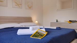 a bedroom with a blue bed with a book on it at Spiaggia Dorata in Peschici