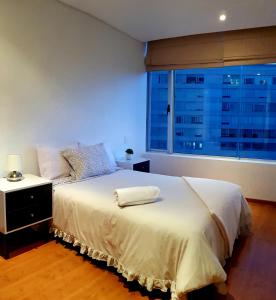 a bedroom with a white bed with a large window at Room In Residential WTC in Mexico City