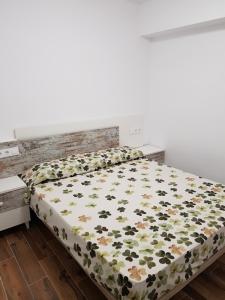 um quarto com uma cama com um edredão floral em Apartamento de lujo en primera línea de la playa de Cullera con vistas al Castillo em Cullera