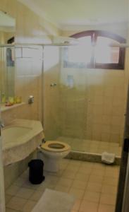 y baño con ducha, aseo y lavamanos. en Pousada La Maison en Iguaba Grande