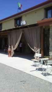 - un bâtiment avec des rideaux et des chaises devant dans l'établissement Agriturismo la vallata, à Masseria Scilva