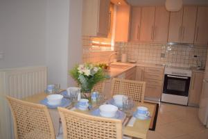 uma cozinha com uma mesa com um vaso de flores em Luxury Apt Near The Airport em Spata