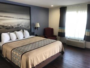 a hotel room with a large bed and a chair at Northgate Motel in El Cajon