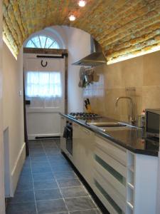 a kitchen with a sink and a stove top oven at Gamekeepers Cottage in Hayfield