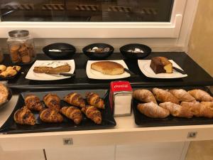 a table with different types of bread and pastries at Hotel Nuova Orchidea in Dresano