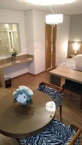 un soggiorno con tavolo e letto di Ives Hotel a Costa Rica