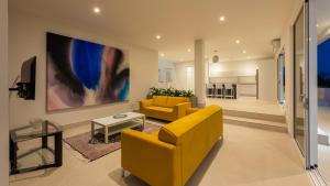 VillaCasaBella Ocean View-Private Pool-Up to 12 Guests في Willibrordus: غرفة معيشة مع أريكة صفراء وطاولة