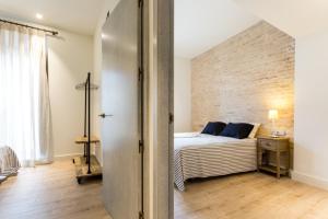 a bedroom with a bed and a brick wall at Apartamentos Lanza in Seville