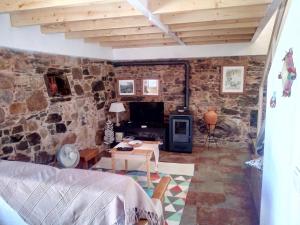 a living room with a stone wall at REFÚGIO DO RAPOSO/CASA VEGA in Montes da Senhora