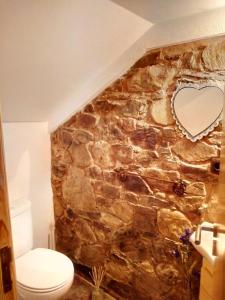 bagno con parete in pietra e specchio a forma di cuore di REFÚGIO DO RAPOSO/CASA VEGA a Montes da Senhora