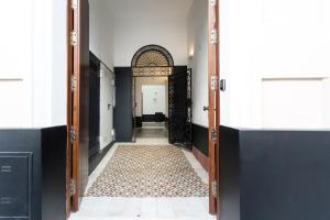 セビリアにあるApartamentos Lanzaの敷物の開いたドア付きの廊下