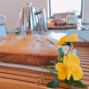 una hogaza de pan sentada en un mostrador con flores amarillas en Fran and Frankie's Bed & Breakfast en Luggate