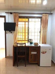 a kitchen with a table and a chair next to a window at The Bright Lotus Guesthouse in Phnom Penh