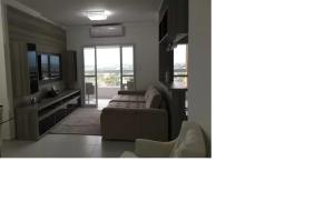 a living room with a couch and a table at Apto pé-na-areia em Bertioga - Indaia Home Club in Bertioga