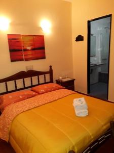 ein Schlafzimmer mit einem großen orangenen Bett und einem Spiegel in der Unterkunft Hotel Paris in General San Martín