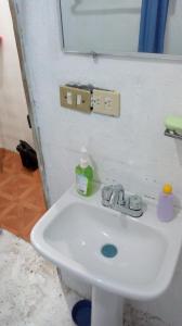 y baño con lavabo blanco y espejo. en Apartamento Acoxpa, en Ciudad de México
