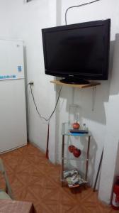 TV de pantalla plana en un estante junto a una nevera en Apartamento Acoxpa, en Ciudad de México