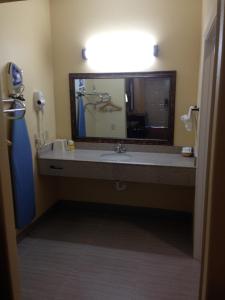 uma casa de banho com um lavatório e um espelho grande em Executive Inn em Dayton