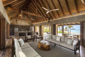 an open living room with a couch and a table at Six Senses Fiji in Malolo