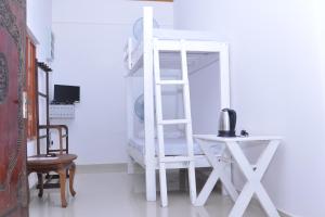 a white ladder in a room with a table and a chair at Sea View Resort in Galle