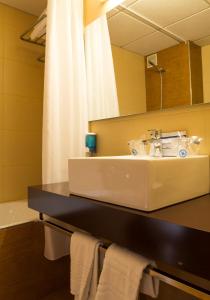 a bathroom with a sink and a mirror at Hotel La Rápita in Sant Carles de la Ràpita