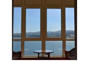 a dining room table with a view of the ocean at Parador de Ribadeo in Ribadeo