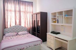 a bedroom with a bed and a desk and a window at Homestay Jasmin Indah, Senawang (free wifi) in Seremban