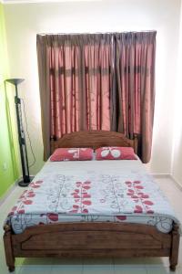 a bedroom with a large bed with pink curtains at Homestay Jasmin Indah, Senawang (free wifi) in Seremban