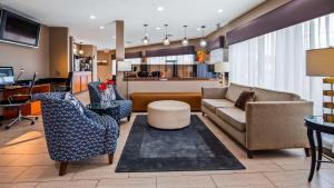 sala de estar con sofá, mesa y sillas en Best Western Airport Inn, en Pearl