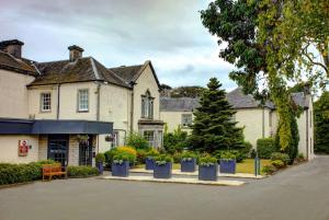 a house with blue pots of plants in front of it at Best Western Plus Dunfermline Crossford Keavil House Hotel in Dunfermline