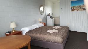 a small room with a bed and a table and a table sidx sidx at Kaikoura Motor Inn in Kaikoura