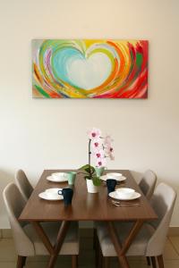 een eettafel met een hart schilderij aan de muur bij LOVELY & COZY HOME @ MIDILLS GENTING in Genting Highlands