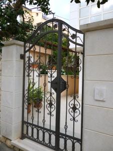 a black gate with potted plants on it at Apartments Jani in Hvar