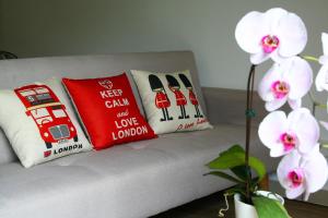 two pillows on a couch with white flowers at CHARMING & COZY HOME @ MIDHILLS GENTING in Genting Highlands