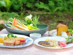 Pension Peppermint House في Hara: طاولة مع أطباق من الطعام وأوعية من الخضروات