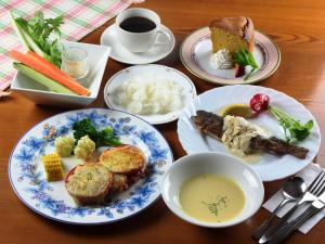 a table with plates of food and a cup of coffee at Pension Peppermint House in Hara