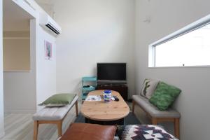a living room with a table and chairs and a television at Shibuya Stay Tokyo A202 in Tokyo