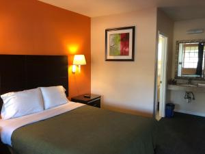 a hotel room with a bed and a window at Arroyo Village Inn in Arroyo Grande +3 photos