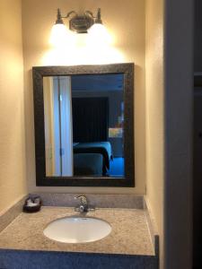 een badkamer met een wastafel en een spiegel bij Arroyo Village Inn in Arroyo Grande
