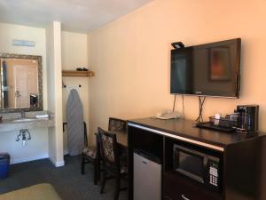 ein Hotelzimmer mit einem Flachbild-TV an der Wand in der Unterkunft Arroyo Village Inn in Arroyo Grande